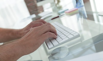 close-up of an employee typing on a personal computer keyboard.