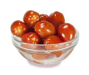 The cherry tomatoes in a glass dish on a white background.