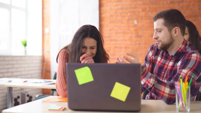 serious man working at the computer. finds a suitable option on the Internet and invites to discuss colleagues. people are discussing. cheerful working atmosphere. 4k