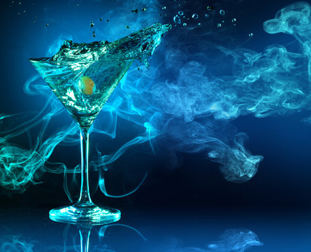 martini cocktail splashing in dark blue smoky background