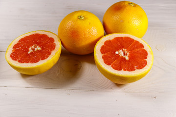 Ripe fresh grapefruits on white wooden table