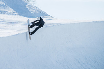 People are enjoying half-pipe skiing / snowboarding