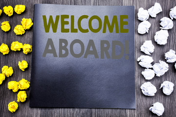 Hand writing text caption inspiration showing Welcome Aboard. Business concept for Greeting Join Member Written on notepad note notebook book wooden background with sticky folded yellow and white