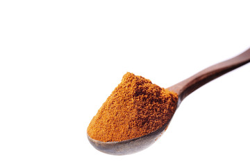 Top view of a wooden spoon full of paprica isolated on white background, shallow depth of field.