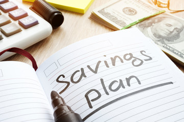 Note with words savings plan and money.