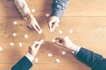 Businessman team work holding two jigsaw connecting couple puzzle piece for matching to goals...