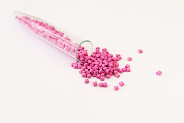 Plastic pallets . Plastic raw materials in granules for industry. Polymeric dye pink on a white background. Plastic granules after processing of waste polyethylene and polypropylene.Polymer.