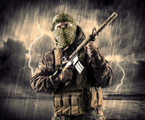 Dangerous armed terrorist with mask and gun in a thunderstorm with lightning