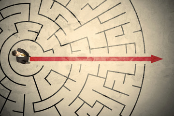 Business person standing in the middle of a circular maze