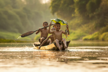 Azja dzieci cieszy się w łodzi na pięknej rzece - 194857252