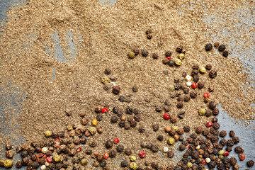Mix of grind black pepper and black, white, red and yellow peppercorn. Selective focus.
