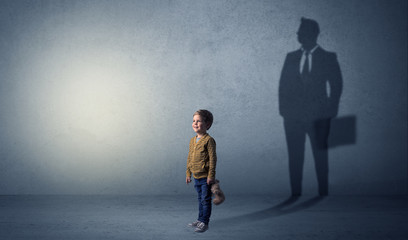 Fototapeta premium Little boy with businessman shadow