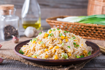 Asian fried rice with eggs and corn close-up on a plate, horizontal
