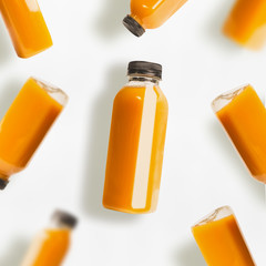 Yellow smoothie or juice bottles pattern on white background, top view, flat lay. Branding copy...