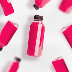 Pink smoothie or juice bottles pattern on white background, top view, flat lay. Branding copy space
