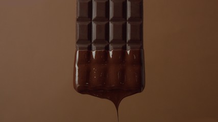 black chocolate bar closeup soaked in liquid chocolate. Different chocolate texture. Sweeter concept