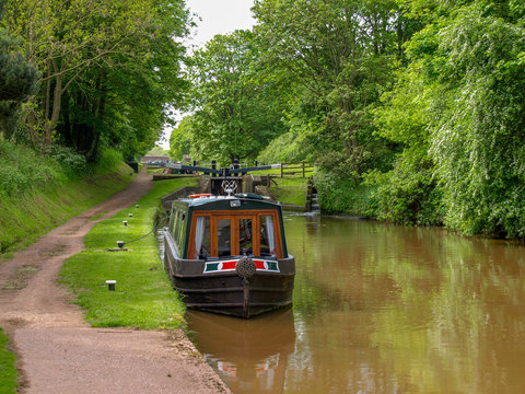 Moored narrowboat between two canal locks  on the Shropshire Union Canal near Audlem in Cheshire, England.