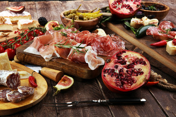 Italian antipasti wine snacks set. Cheese variety, Mediterranean olives, pickles, Prosciutto di Parma and salami