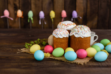 Easter cake and colorful eggs on a wooden table. It can be used as a background