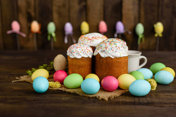 Fototapeta na wymiar Easter cake and colorful eggs on a wooden table. It can be used as a background