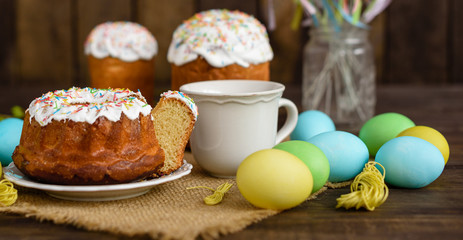 Easter cake and colorful eggs on a wooden table. It can be used as a background