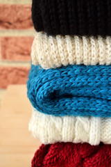 Knitted clothes of different colours are piled carefully