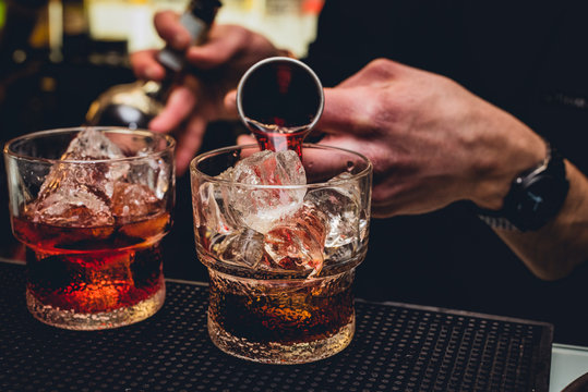 Bartender versa vermut rosso nel bicchiere mentre prepara un Americano freddo