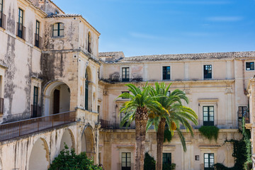 Fototapeta na wymiar Picturesque inner courtyard with palm trees in Noto