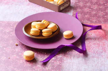 Orange Macarons, on light purple floral background.