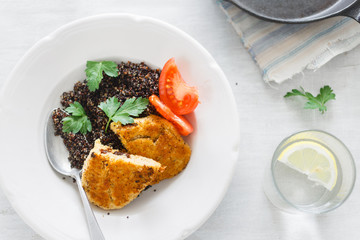 Top View Healthy Vegetarian Food. Plate with black quinoa and oatmeal cutlets with prunes on white wooden table with lemon water. Copy space