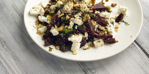 Beetroot salad with cottage cheese and walnuts. European cuisine. Top view. Vegan dish. Vegetarian appetizer. Simple side dish. Wide photo.