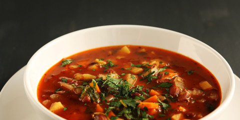 Tomato soup with red beans, potato and carrot. Vegan. European cuisine. Side view. Vegetarian dish. Main course. Wide photo.