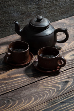 Chinese tea utensils - dark clay teapot and cups, vertical