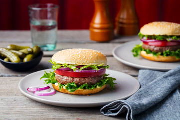 Burger on a plate. Wooden background. Copy space.