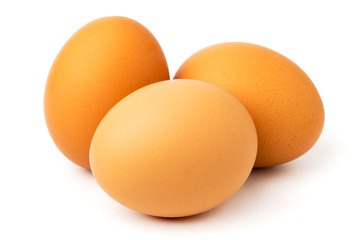Three chicken eggs on a white, close up.