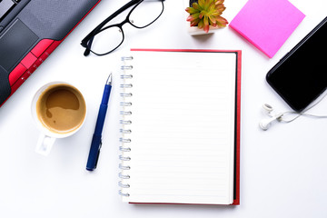 Top view or Flat lay style for business with copy space of workspace with laptop , pen , notebook , cup of coffee , sticky note eyeglasses and mobile phone and earphone on white table background