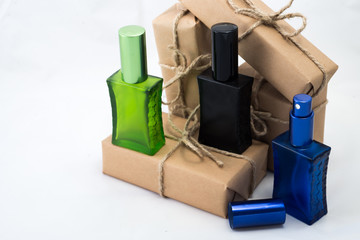 Stack of handcraft gift boxes nad parfume glasses on white background