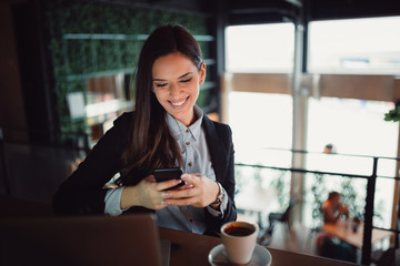 Beautiful smiling girl using smartphone.