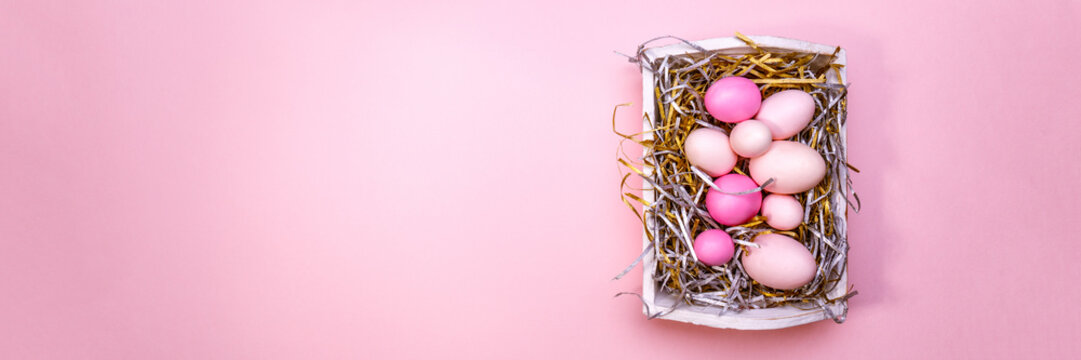 Eggs in a white tray. Creative Easter concept. Modern solid pink background.