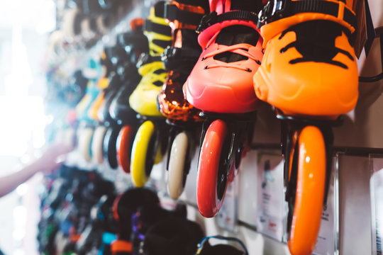 Assortment roller skates isolated in store shop, choosing and buy color roller-skates on backgraund sun flare, healthy and activity lifestyle concept, man consider sport footwear for rollerblade