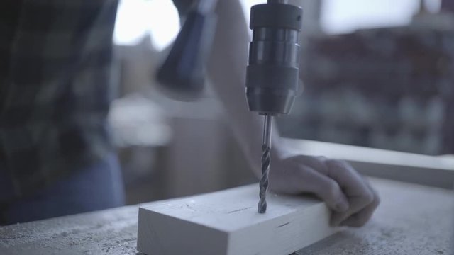 Handsome man in his fourties working with tools and wood at his workplace
