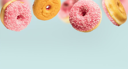 Falling or flying pink glazed doughnuts with sprinkles in motion at pastel blue background , border...
