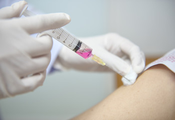 Soft focus nurses are vaccinations to patients using the syringe.Doctor vaccinating women in...