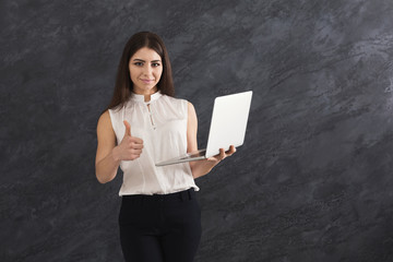 Naklejka premium Happy woman with laptop on gray background
