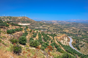 Fototapeta na wymiar Aerial view of farms and wind power generators on hills