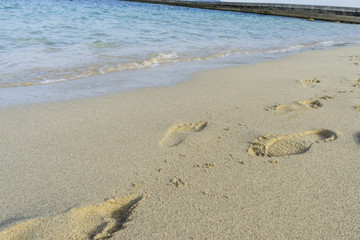 Footprints in the sand of a beach by the Mediterranean sea on the island of Ibiza in Spain, holiday and summer scene