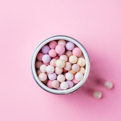 Pearl make up powder on pink pastel background. Top view. Copy space.