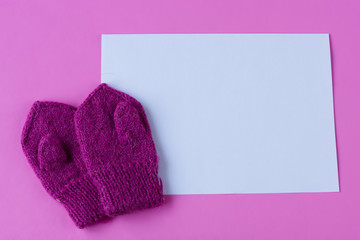 Children's mittens on pink background. Space for text