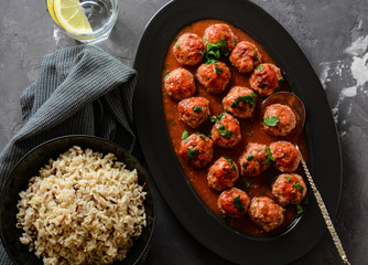 Meatballs in a spicy tomato sauce with fresh aromatic herbs. Rice and pasta.