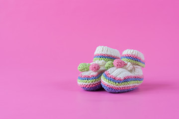 Baby's bootees on pink background. Space for text